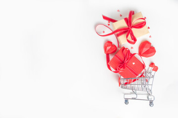 Valentine day sale concept, Still life composition with festive gifts box, red heart and shopping cart on white background copy space for text. Shopping online for Christmas new year, Valentine day