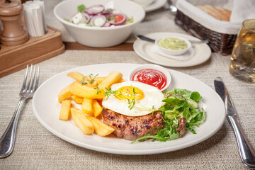 Beef cutlet, fried egg and fries