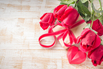 Valentines Day concept, Red Roses and Gift Boxes with Festive Ribbon and Heart Decor on White wooden table background copy space. Romantic floral background.