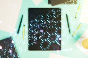Double exposure of technology hologram with hexagon and digital tablet on background, top view. Research and development software concept