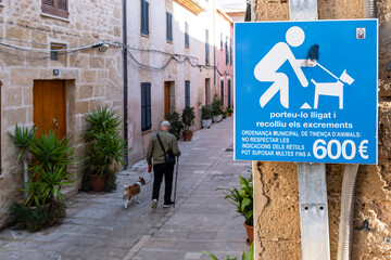 man with a dog and placard forcing the collection of canine excrement, Alcudia, Mallorca