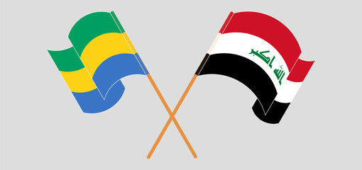 Crossed and waving flags of Gabon and Iraq