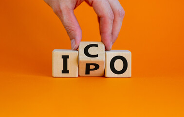 IPO vs ICO. Hand turns a cube and changes the word 'IPO - initial public offering' to 'ICO -...
