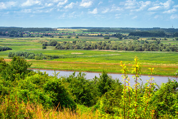 Oder River as a natural country border between Germany and Poland. Summer rural landscape with a forest and an agriculture field