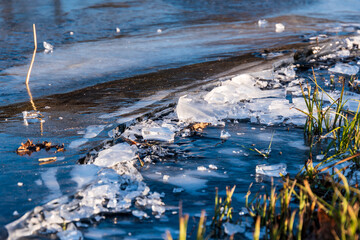 Just frozen ice and pieces of ice on the shore of the pond