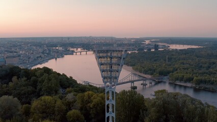 turned off the light tower at the football stadium before turning on. Switching on the light tower of a football stadium against a sunset and a night city cinematic smooth movement of a drone