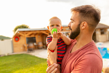 Fototapeta premium Father carrying his baby boy in his arms