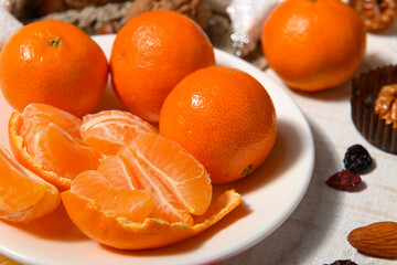 sweet food background for christmas or holiday decoration - tangerines, nuts and dried fruits on wool