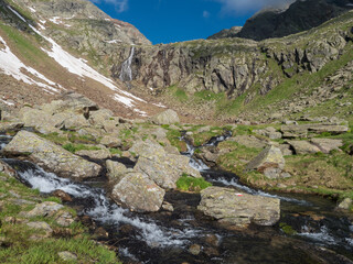 view of wild river, waterfall from melting ice at hiking trail, Stubai Hohenweg Tyrol, Austrian Alps