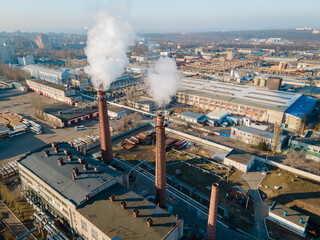 Aerial view smoke clouds from boiler pipes on industrial area at winter