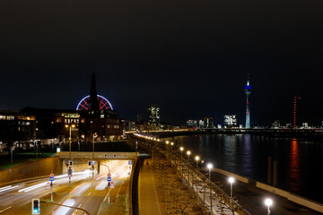 Fototapeta premium High angle, outdoor night scenery over riverside of Rhine River and street with light of traffic movement in Düsseldorf, Germany.