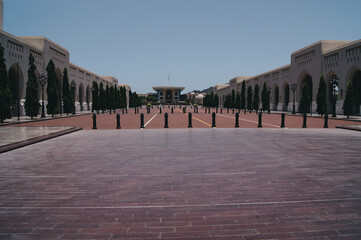 a courtyard with pillars and a building in the background