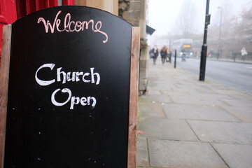 Sign saying Welcome Church Open indicating that the public christian church is open and welcoming believers during the covid 19 global pandemic. Churches have been closed during the lockdown