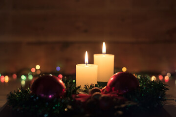 Candles and Christmas decorations on dark background with lights