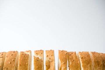 Fresh bread sliced baguette on rustic white table top view