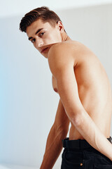 Athletic man with a bare back bent over back and black pants