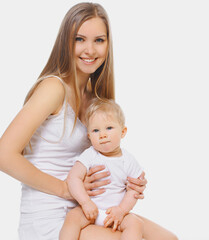 Portrait of cheerful smiling mother and baby playing together over a white background