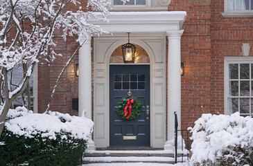 Front door with Christmas wreath with snow covered trees