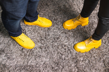 Demonstrating trendy colors 2021 - Gray and Yellow. Couple in similar clothes standing on fluffy...