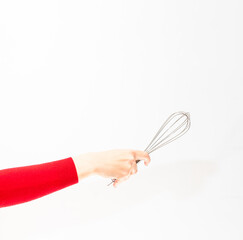 Metal whisk in the girl's hand on a white background.