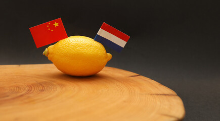 Netherlands Dutch Chinese flags in a lemon on a chopping block representing strained soured...