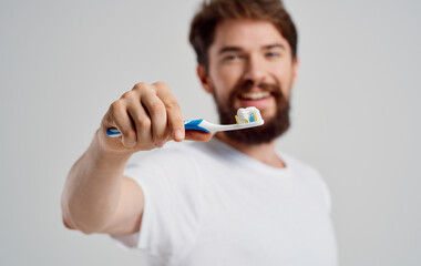man With a toothbrush in hand oral cavity care morning procedures snow-white smile