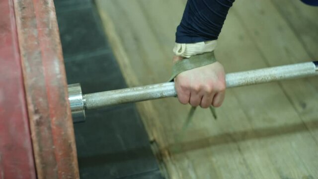 close up of the athlete's hand which takes the bar with his hand and twists the straps