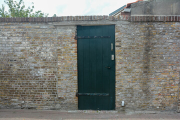 An old closed  green door in an old wall