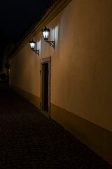 light from street lighting cobblestones and Charles bridge at night in the center of Prague