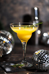Mimosa coctail with orange juce and champagne in trendy colors gray and Illuminating yellow of the 2021. New Year or Birthday party with a mirror disco balls.