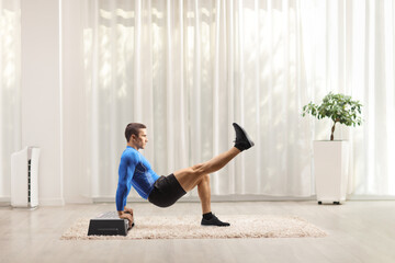 Fit strong man exercising on a step aerobic platform with his leg up