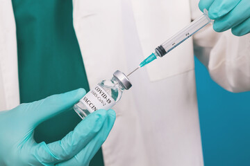 doctor hand with coronavirus vaccine and injection or syringe