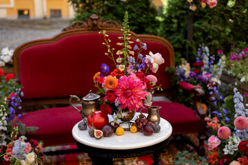 wedding decoration on the white table with fruits, flowers and antiques