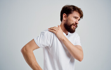 man has shoulder pain and white t-shirt dislocation health problems