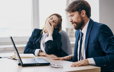 tired man and woman at work colleagues at work laptop professionals