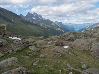 Fototapeta na wymiar Summer view of Stubai valley from Bremer Hutte at hiking trail, Stubai Hohenweg, rock, boulders and moutain peaks. Tyrol Alps, Austria