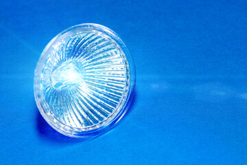 Indoor halogen lamp on a textured blue surface. Copy space. Background for text. Selective focus