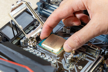 Installing the CPU on the motherboard. Assembling the computer. Technician installs the processor....