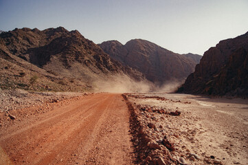 a dirt road with a large cloud of smoke coming out of it