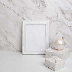 Christmas composition. White framed Christmas decorations and gifts on a marble background