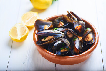 
steamed mussels with served in a Russian bowl on a white background