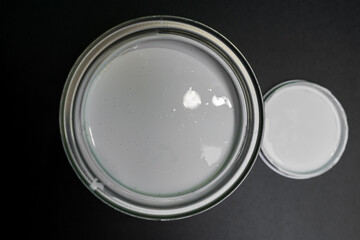 white paint can top view black background