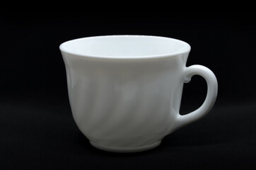 White cup on dark background with selective focus