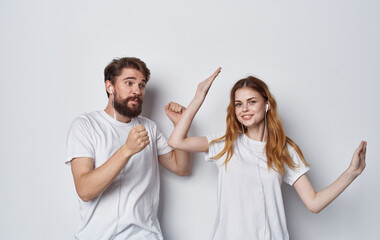 Happy friends in headphones listens to music and dances on a light background