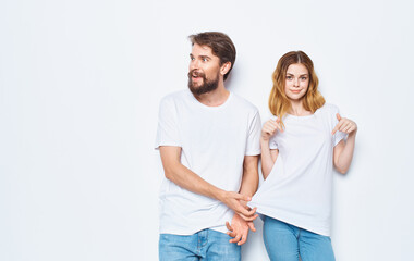 Man and woman in identical t-shirts on a light background jeans family fashion style