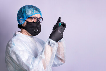 A doctor in medical uniform and wearing respirator and gloves with a syringe for an injection getting ready for vaccination.