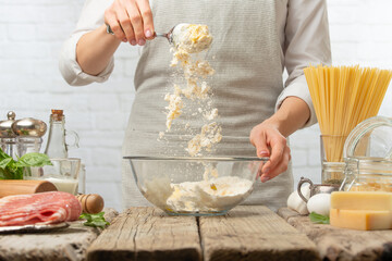 Professional chef mix ingredients in glass bowl for preparing dough. Backstage of cooking pasta alla carbonara. Traditional italian dish on white background. Cooking process concept.