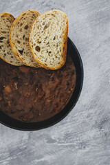 plant-based food, vegan brazilian feijoada with beans and plant-based meats with toasted bread slices