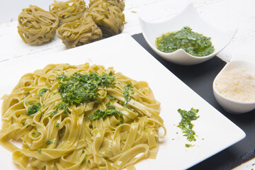 plate of noodles with grated cheese and pesto