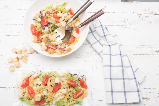 Pasata salad with fresh vegetables on a wooden table